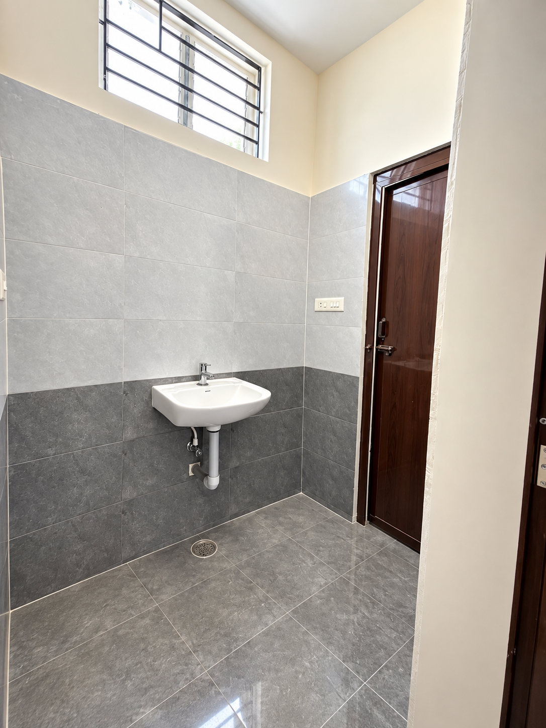 Fine Dine Academy restroom wash area with wall-mounted basin and tiled walls
